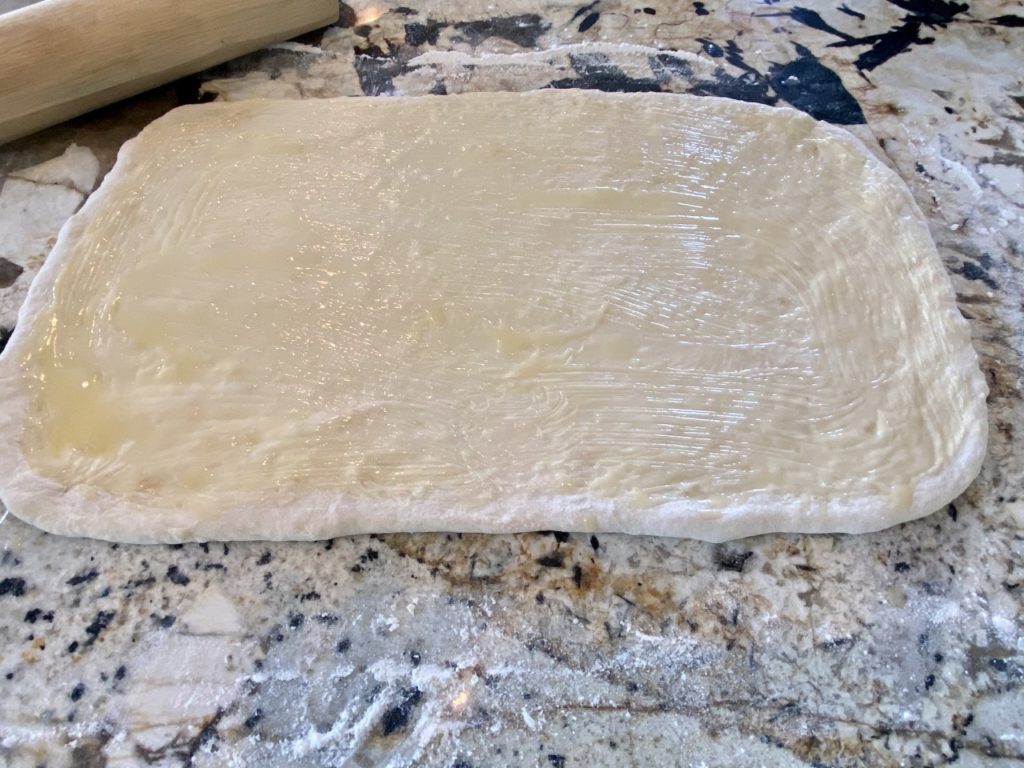 The dough is completely brushed with melted butter.