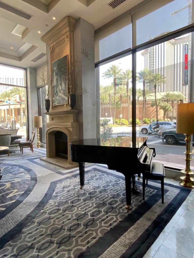 The common area at the Loews New Orleans Hotel with its fireplace and baby grand piano are absolutely stunning! New Orleans Family Vacation 