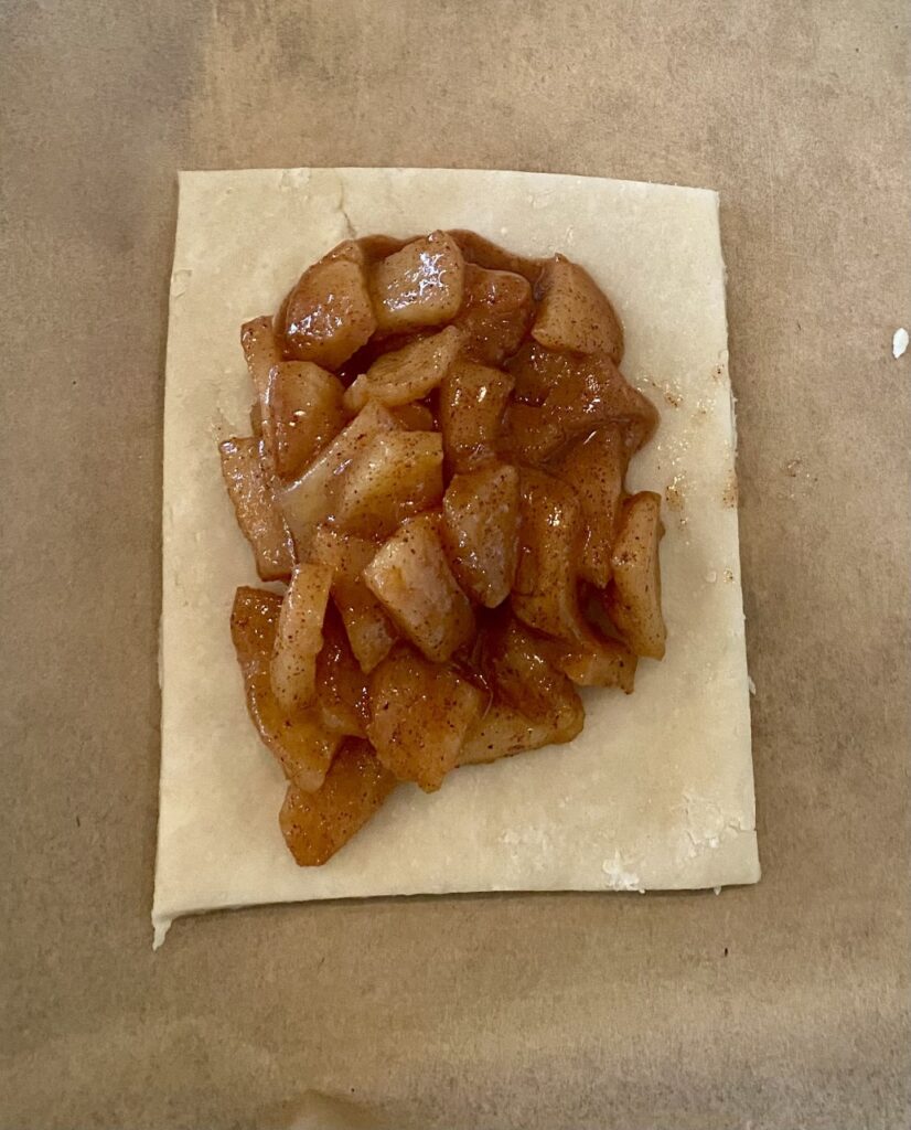 The Honeycrisp apple filling for our Spiced Apple Hand Pies is being put onto the individual dough rectangles. 